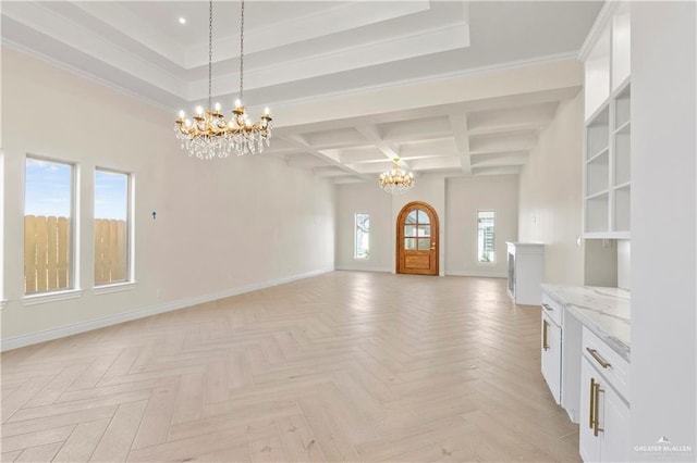 unfurnished living room with beam ceiling, a wealth of natural light, light parquet floors, and a notable chandelier