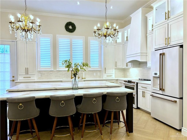 kitchen featuring premium range hood, high quality fridge, tasteful backsplash, a kitchen island, and range