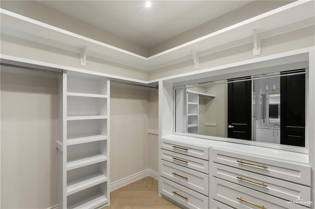 spacious closet featuring light hardwood / wood-style floors