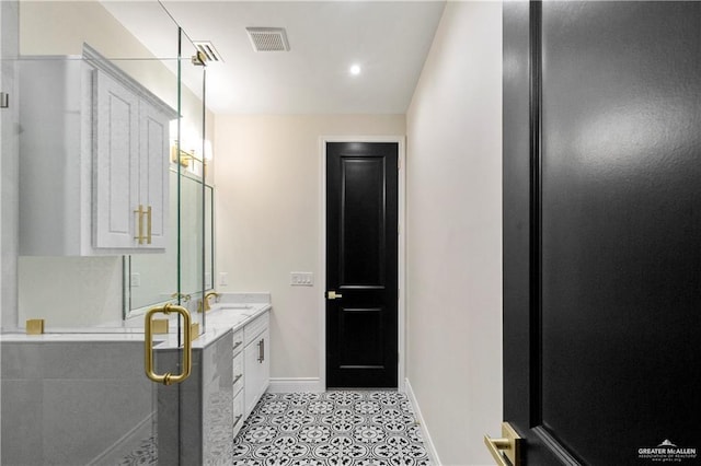 bathroom featuring tile patterned floors, vanity, and a shower with shower door