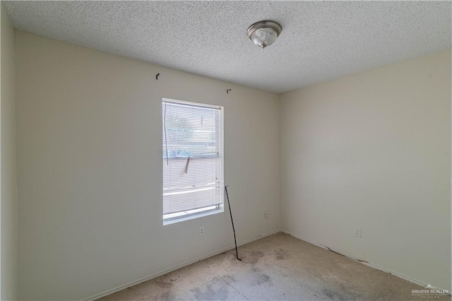 carpeted spare room featuring a textured ceiling