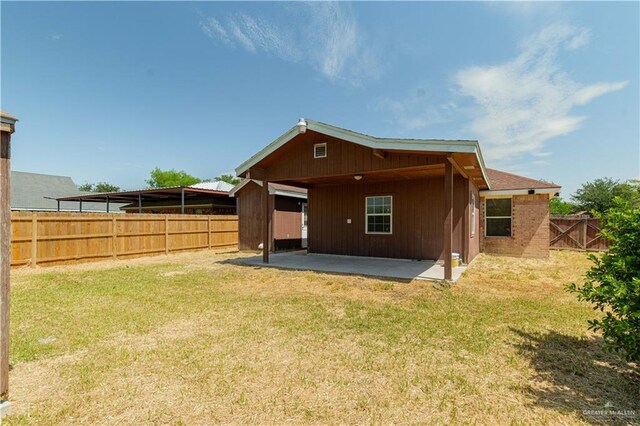 back of property featuring a lawn and a patio