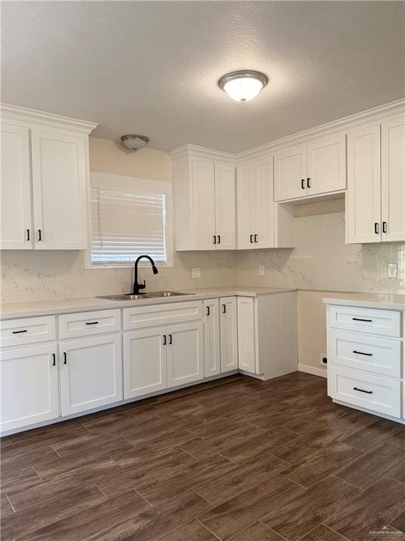 kitchen with white cabinets, a textured ceiling, dark hardwood / wood-style floors, and sink