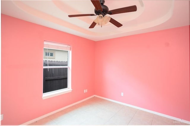 spare room with a tray ceiling and ceiling fan