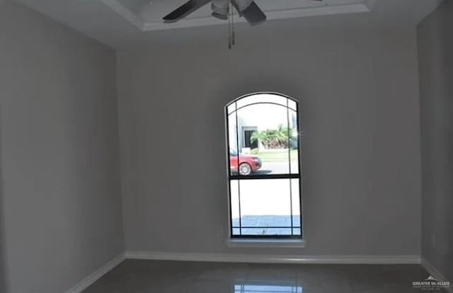 unfurnished room featuring ceiling fan and dark tile patterned flooring