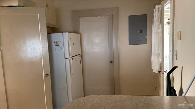 kitchen featuring electric panel and freestanding refrigerator