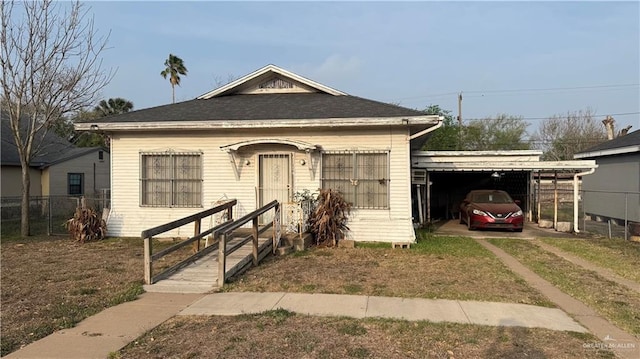 bungalow-style home featuring a carport, fence, and driveway