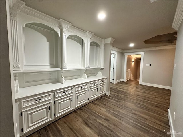 interior space featuring recessed lighting, dark wood-type flooring, an upstairs landing, baseboards, and crown molding