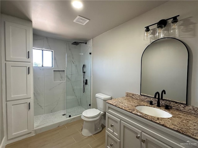 full bathroom with toilet, a marble finish shower, vanity, and visible vents