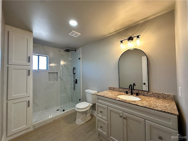 full bath featuring visible vents, toilet, vanity, and a marble finish shower