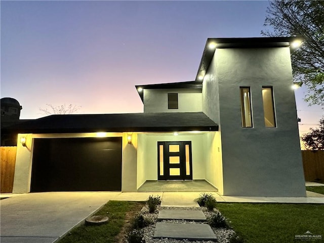 modern home with concrete driveway and stucco siding