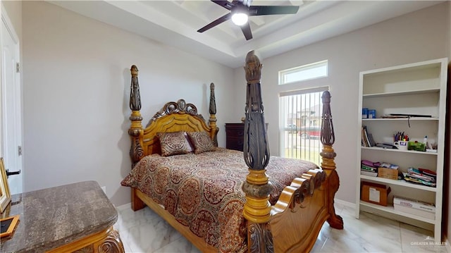 bedroom featuring baseboards, marble finish floor, ceiling fan, and a tray ceiling