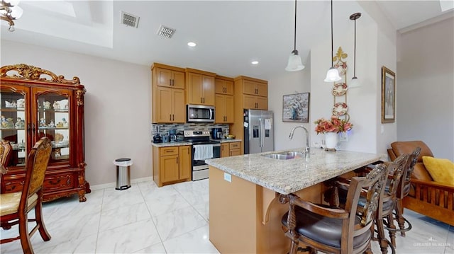 kitchen featuring a kitchen breakfast bar, appliances with stainless steel finishes, a sink, a peninsula, and recessed lighting