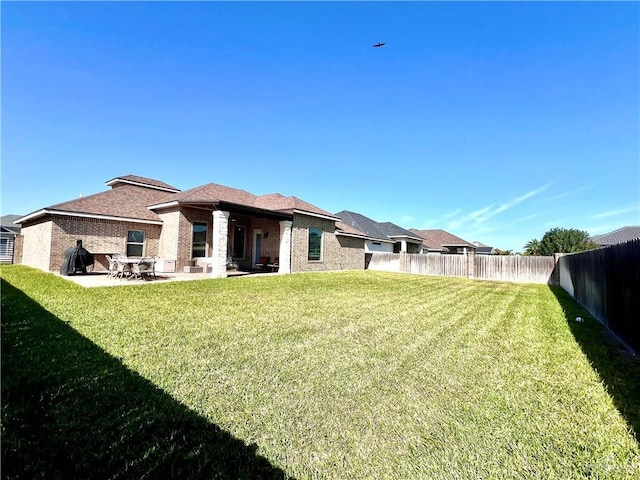 back of property featuring a yard and a patio