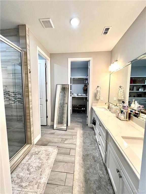 bathroom with a shower with door and vanity