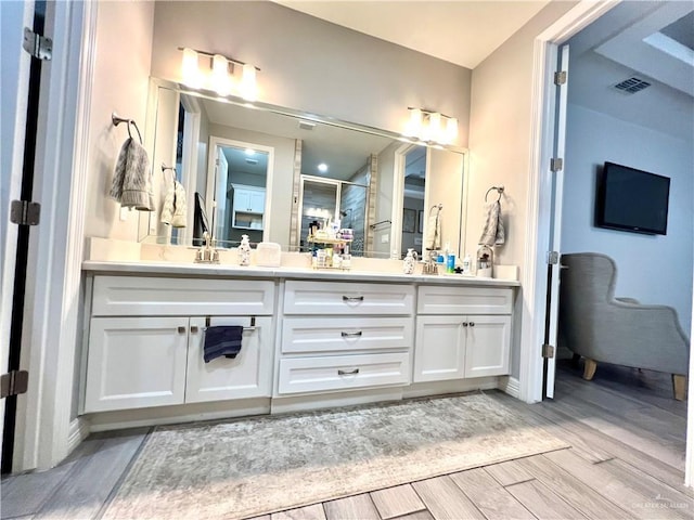 bathroom with a shower with shower door and vanity