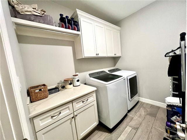 laundry room featuring washer and dryer and cabinets