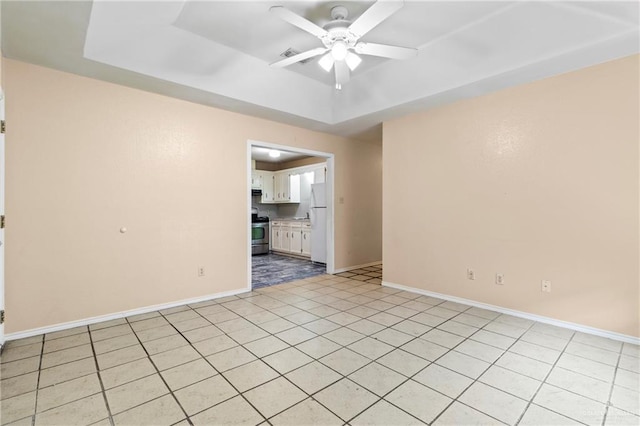 2117 S 30 1/2 St, Mcallen, TX 78503 - empty room with ceiling fan, a tray ceiling, baseboards, and light tile patterned flooring