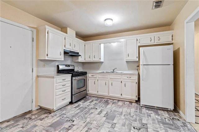 2117 S 30 1/2 St, Mcallen, TX 78503 - kitchen with freestanding refrigerator, stainless steel gas range, under cabinet range hood, a sink, and light countertops