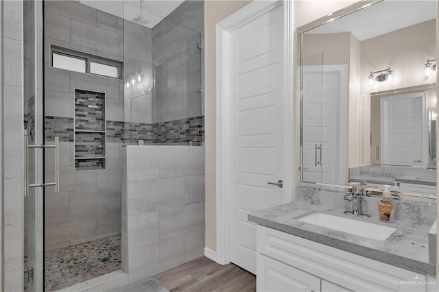 bathroom with vanity, hardwood / wood-style flooring, and a shower with shower door