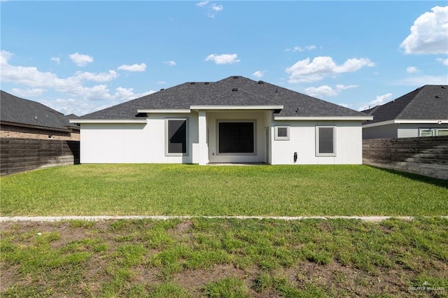 rear view of house featuring a lawn