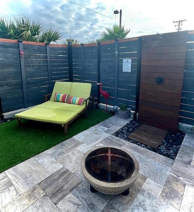 view of patio / terrace featuring an outdoor fire pit and fence