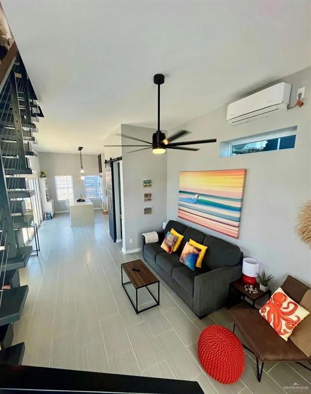 living area featuring a ceiling fan and a wall mounted air conditioner