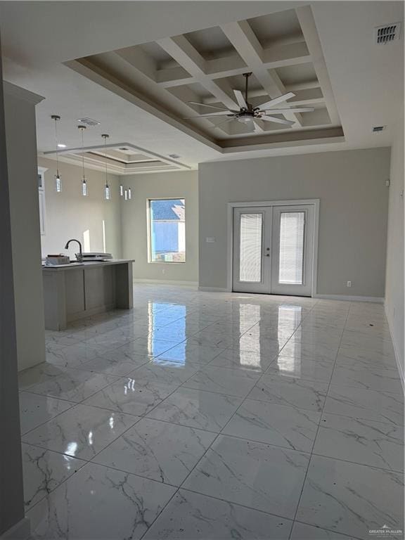 empty room featuring coffered ceiling, a towering ceiling, crown molding, ceiling fan, and french doors