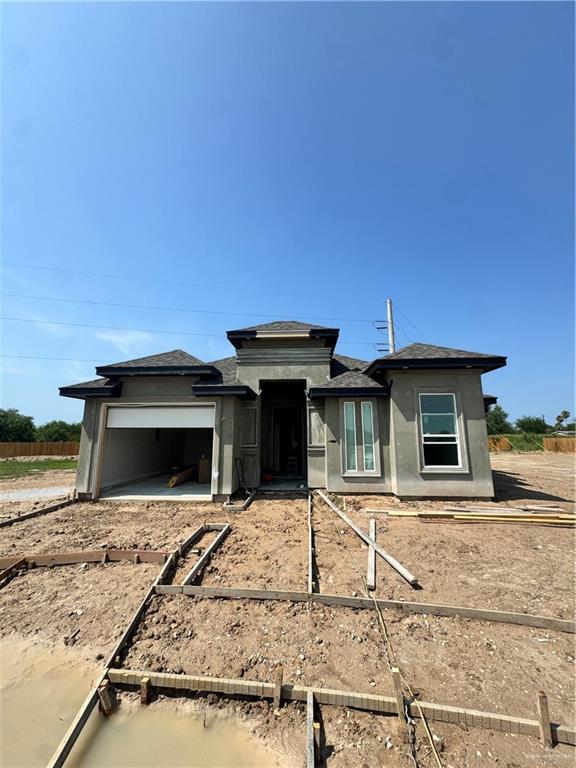 912 41st St, San Juan, TX 78589 - prairie-style house with a garage and dirt driveway