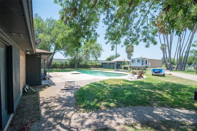 view of swimming pool featuring a yard and a patio