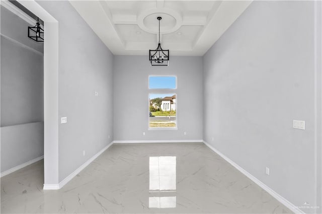 empty room with an inviting chandelier, a raised ceiling, and coffered ceiling