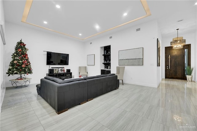 living room featuring a tray ceiling and a chandelier