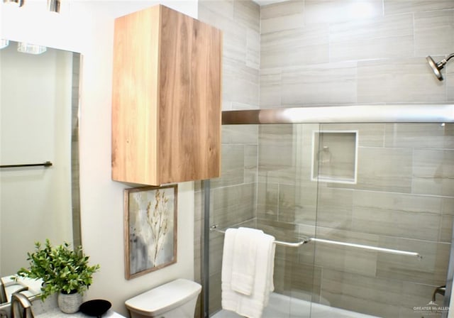 bathroom with an enclosed shower and toilet