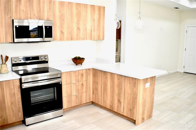 kitchen with light brown cabinets, hanging light fixtures, light hardwood / wood-style flooring, kitchen peninsula, and stainless steel appliances