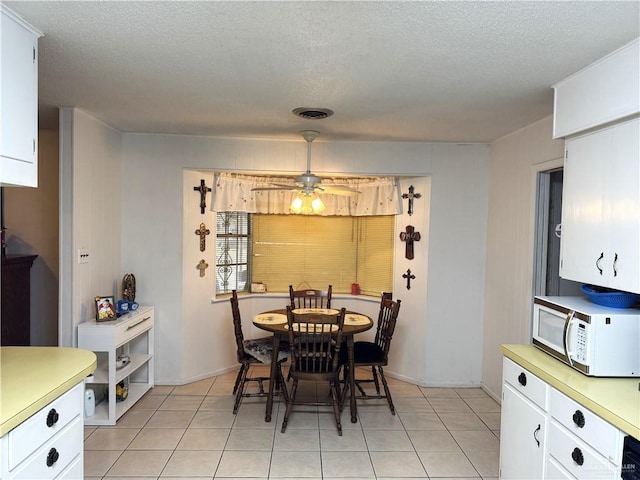 dining room with light tile patterned floors, a textured ceiling, and ceiling fan