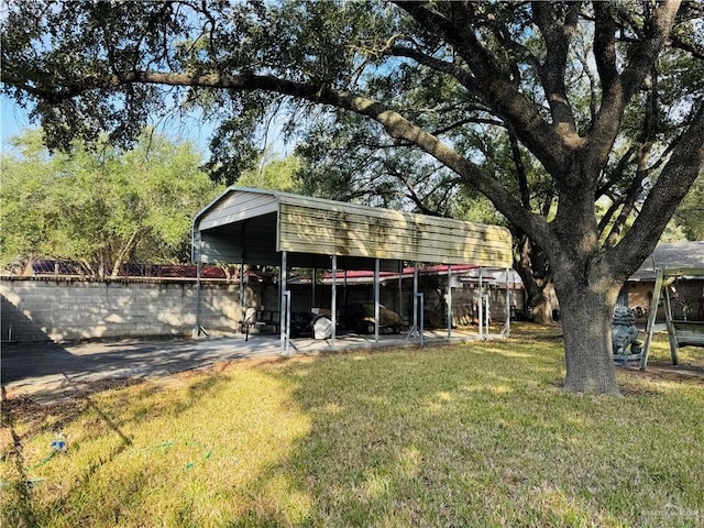 back of house with a carport and a lawn