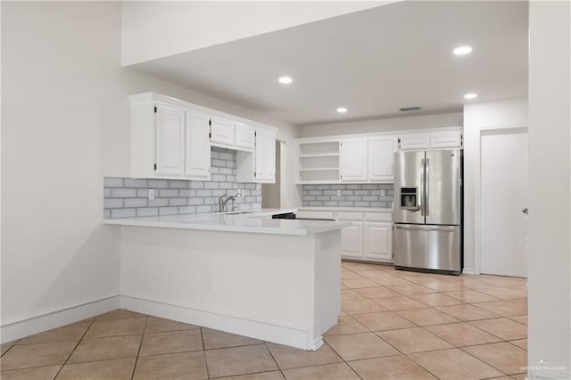 2702 Lazy Lake Dr, Harlingen, TX 78550 - kitchen with stainless steel fridge with ice dispenser, light countertops, decorative backsplash, a peninsula, and light tile patterned floors