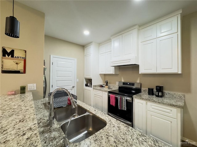 kitchen with sink, light stone counters, pendant lighting, stainless steel range with electric stovetop, and white cabinets