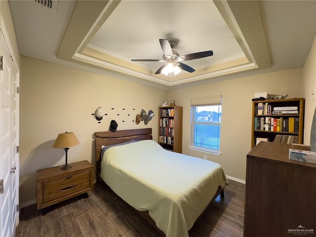 bedroom featuring a raised ceiling and ceiling fan