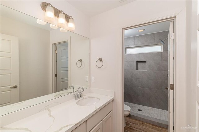 14451 Chalk Ridge Dr, Mcallen, TX 78504 - bathroom with vanity, toilet, tiled shower, and wood finished floors