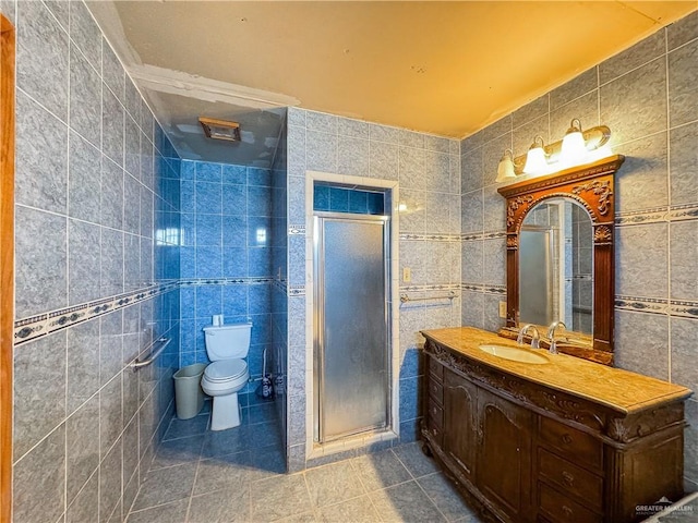 bathroom featuring vanity, tile patterned flooring, toilet, tile walls, and walk in shower