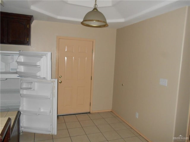 kitchen featuring tile counters, dark brown cabinets, light tile patterned floors, and pendant lighting