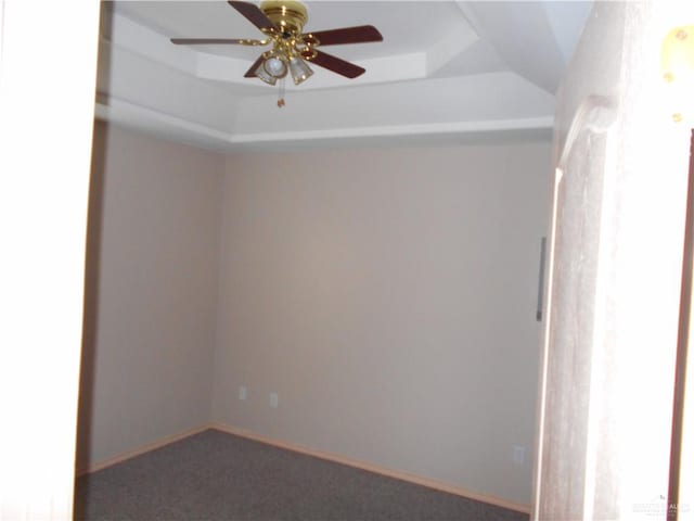 spare room featuring carpet, a raised ceiling, and ceiling fan