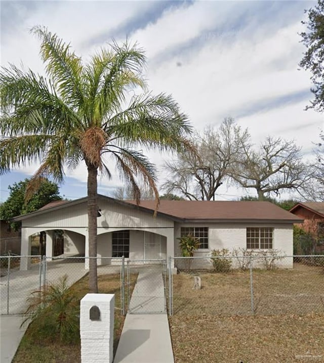 view of front facade with a fenced front yard, driveway, and a gate