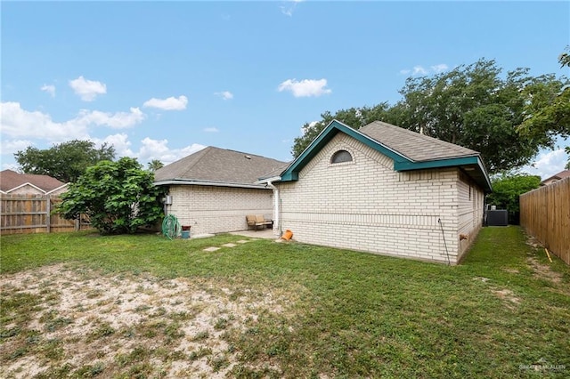 6800 N 35th St, Mcallen, TX 78504 - rear view of house featuring brick siding, a fenced backyard, a lawn, and central AC unit