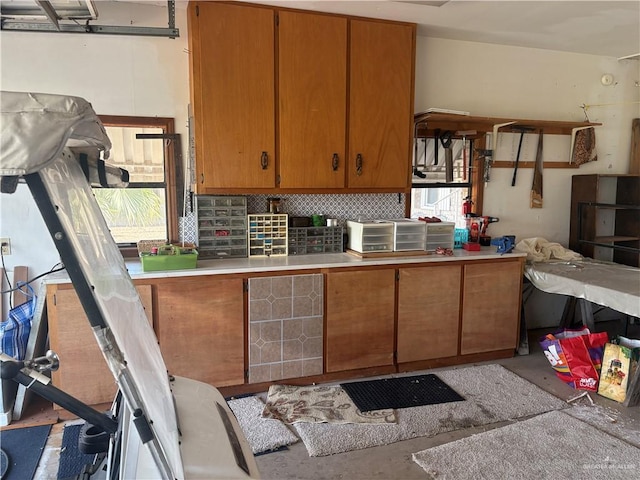911 Santa Anna Dr, Alamo, TX 78516 - kitchen featuring concrete flooring, light countertops, tasteful backsplash, and brown cabinets
