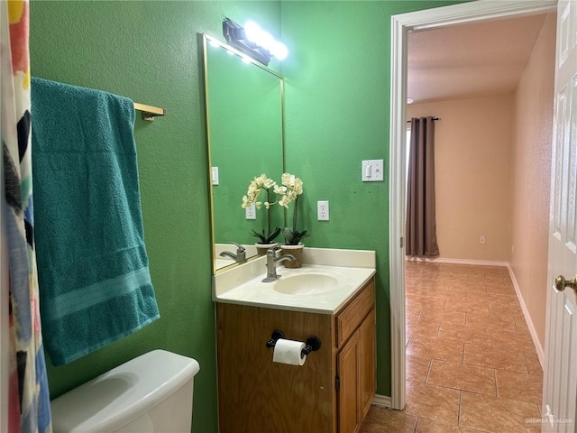 bathroom featuring tile patterned floors, vanity, and toilet