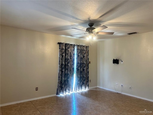 unfurnished room with a textured ceiling, tile patterned floors, and ceiling fan