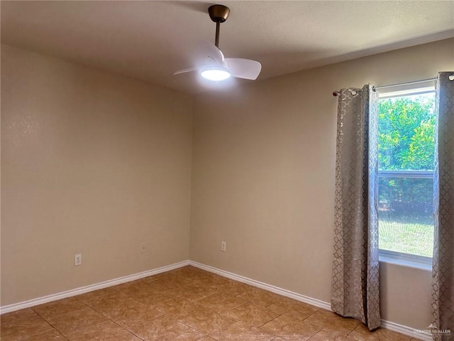 spare room featuring ceiling fan and a healthy amount of sunlight