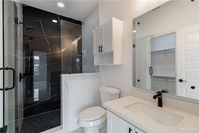 bathroom featuring vanity, toilet, and an enclosed shower